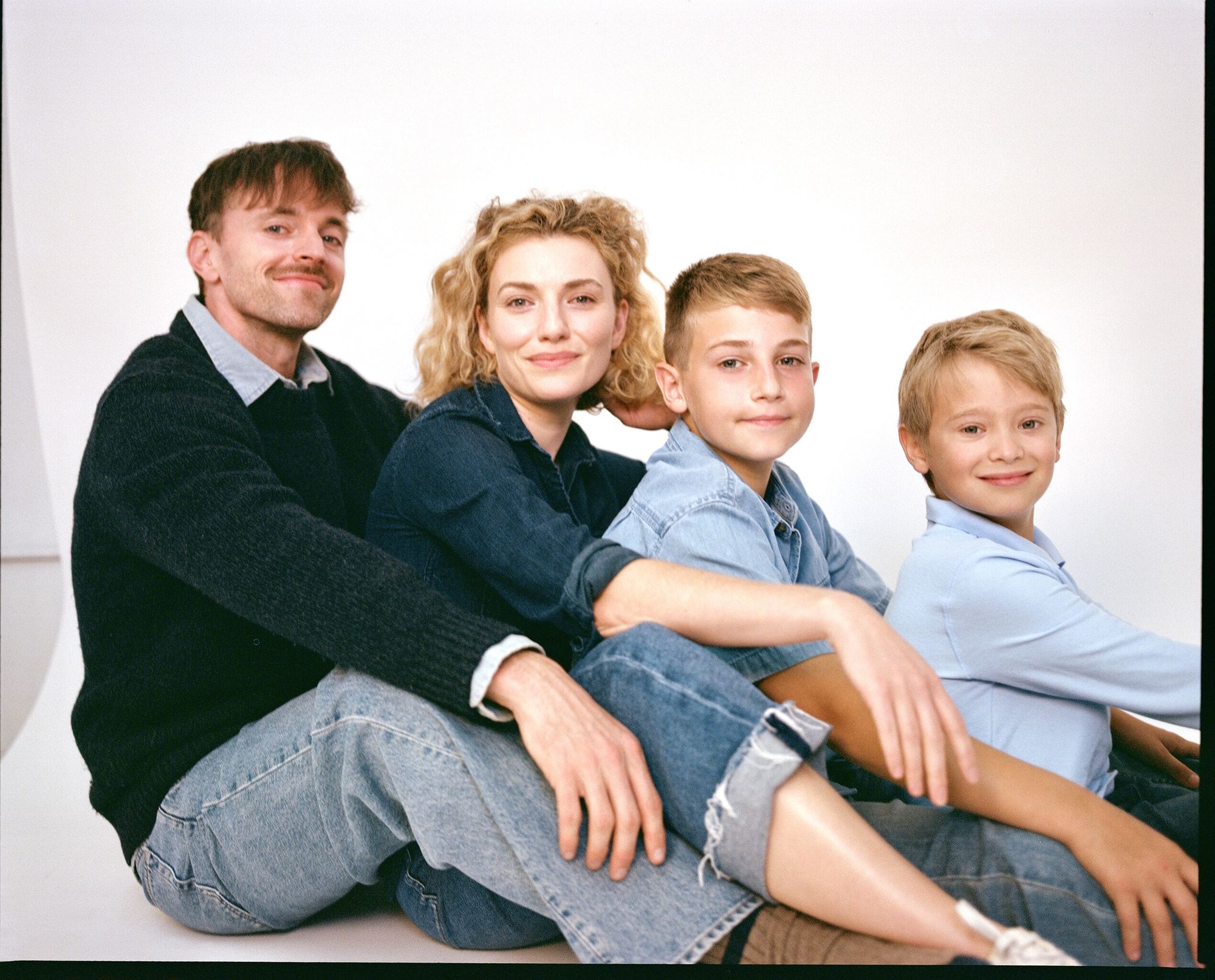 The family sits together on a studio floor.